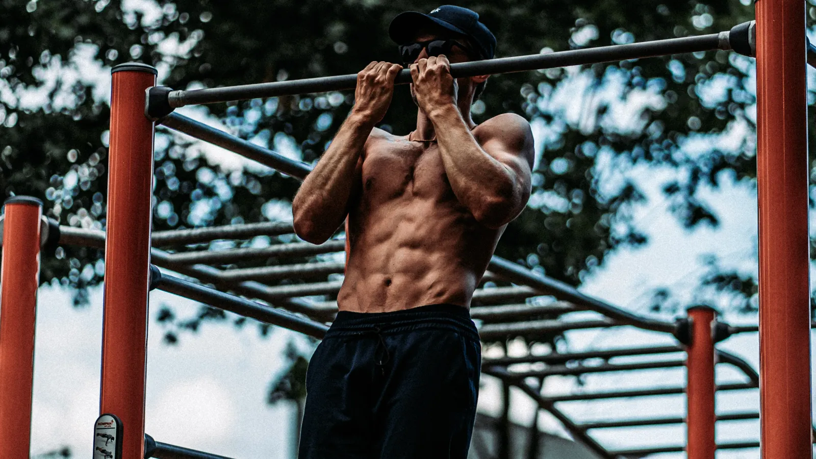 Man doing pull-ups on an outdoor bar